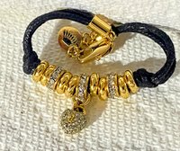Juicy Couture Rhinestones pave pendant with Gold tone high gloss beads on black cord accent.