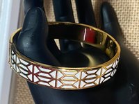 Gold tone with white enameled pattern Stella & Dot Bangle bracelet