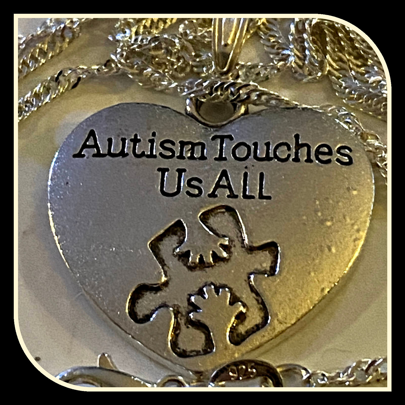 Silver necklace with Autism awareness message
