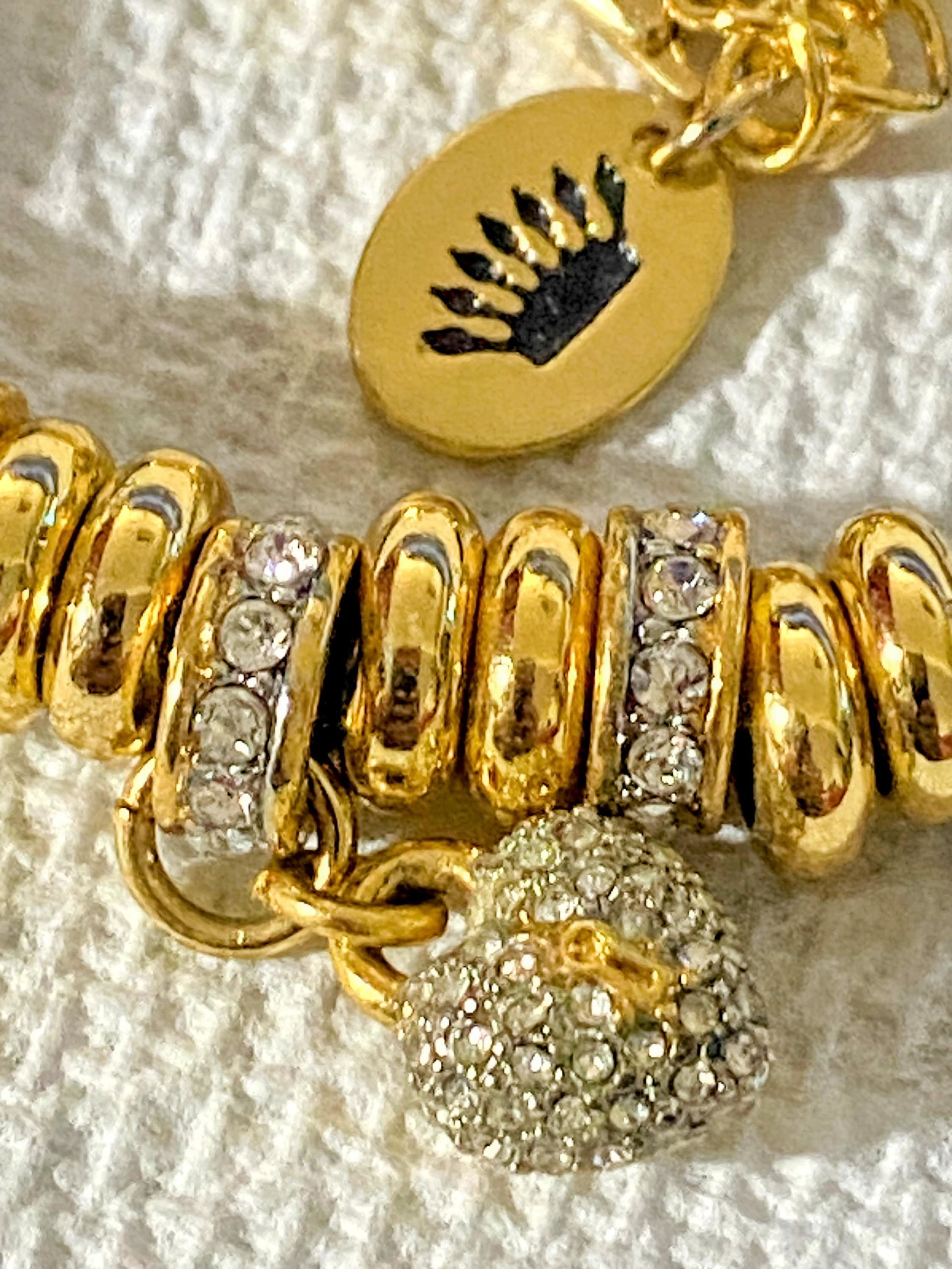 Juicy Couture Rhinestones pave pendant with Gold tone high gloss beads on black cord accent.