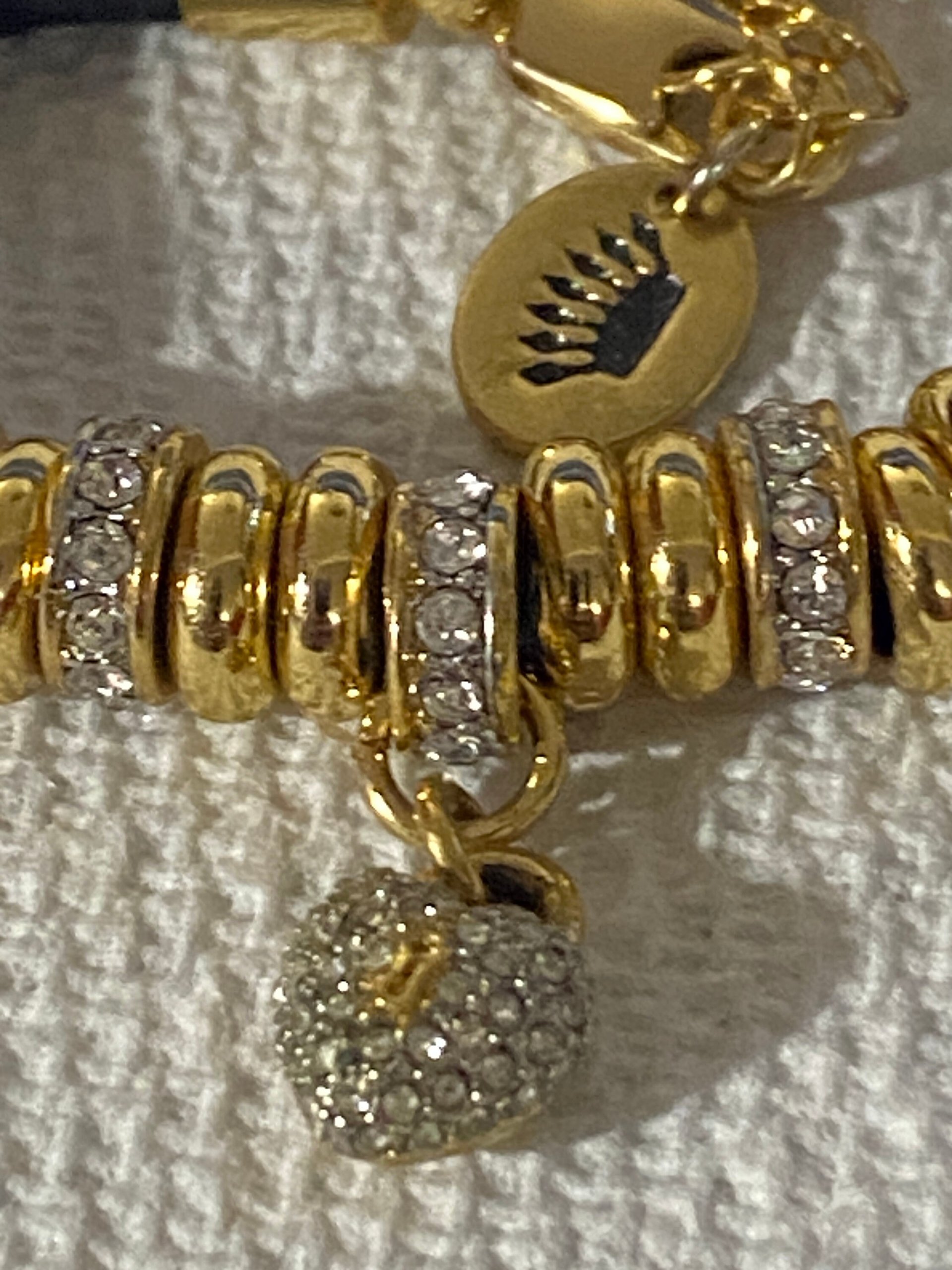Juicy Couture Rhinestones pave pendant with Gold tone high gloss beads on black cord accent.