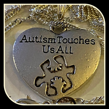 Silver necklace with Autism awareness message